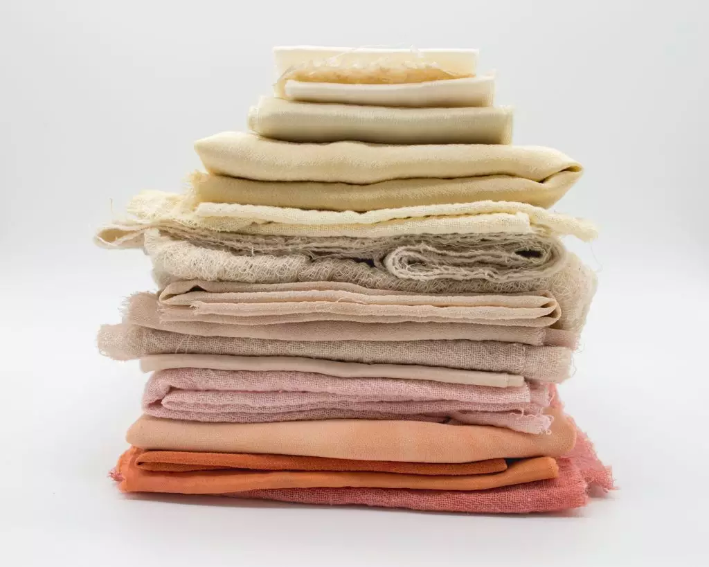 A pile of multicolored hemp fabric pieces are stacked in a neat pile.