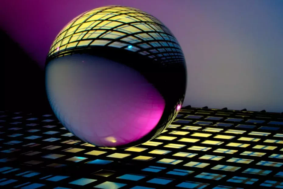 An orb refracts a black keyboard on the top and purple light on the bottom.